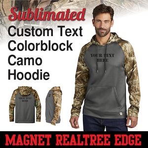 May include: A gray hooded sweatshirt with camo sleeves. The front of the sweatshirt has the text "YOUR TEXT HERE" printed on it. The sweatshirt is a colorblock design with a gray body and camo sleeves.