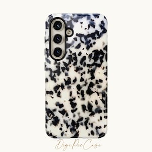May include: A white phone case with a black and white tortoise shell pattern. The case has a raised camera bump with three lenses.