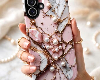 May include: A rectangular smartphone case featuring a pink and white marble pattern with gold veining accents. The surface is decorated with various sizes of white faux pearls and small gold metallic beads. The case has a black camera lens cutout.
