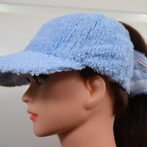 Dameshonkbalpet in babyblauwe chenille met een hoge opening voor een paardenstaart zonder dat er speldjes of houder nodig zijn