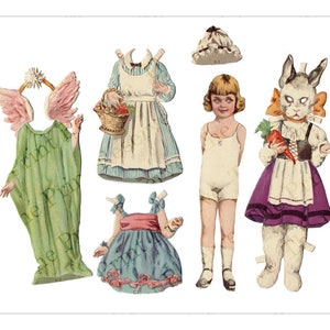 Puede incluir: Un conjunto de mu&ntilde;ecas de papel vintage que incluye una ni&ntilde;a, un conejo y un &aacute;ngel. La ni&ntilde;a tiene el pelo rubio y lleva un vestido blanco. El conejo lleva un vestido morado y blanco y un delantal blanco. El &aacute;ngel lleva una t&uacute;nica verde con alas rosas.