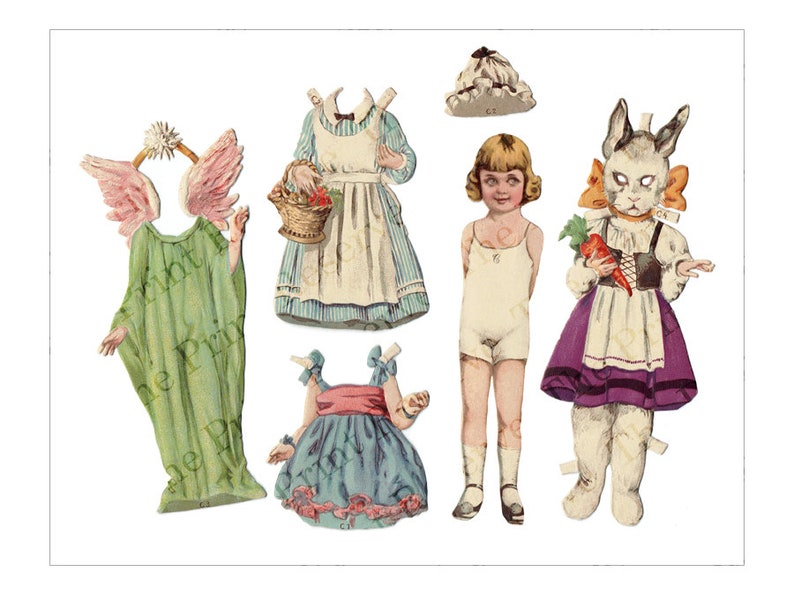 Puede incluir: Un conjunto de mu&ntilde;ecas de papel vintage que incluye una ni&ntilde;a, un conejo y un &aacute;ngel. La ni&ntilde;a tiene el pelo rubio y lleva un vestido blanco. El conejo lleva un vestido morado y blanco y un delantal blanco. El &aacute;ngel lleva una t&uacute;nica verde con alas rosas.