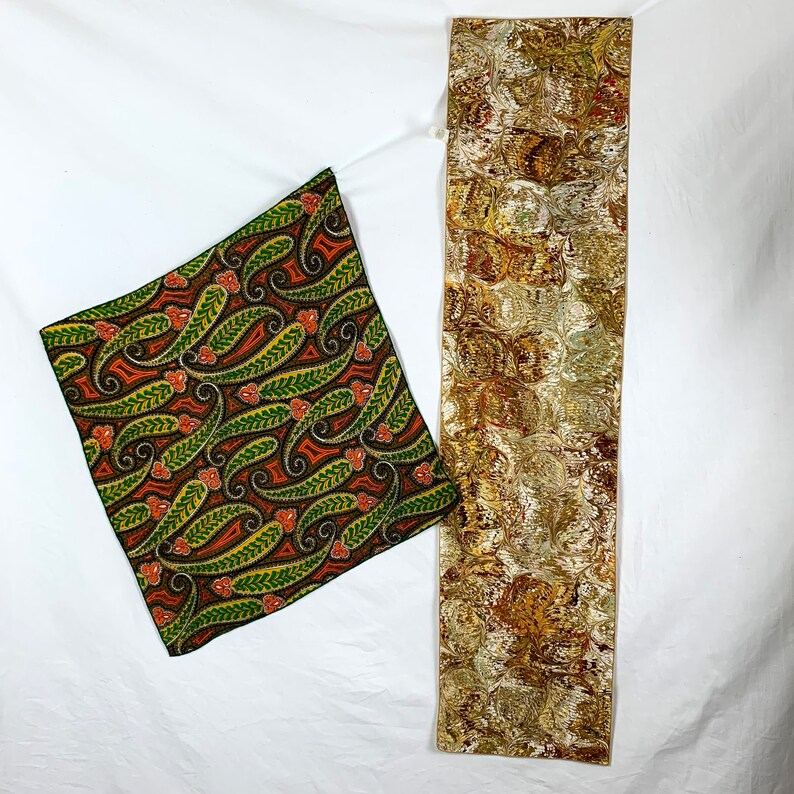 Peut inclure: Deux carr&eacute;s de tissu avec des motifs paisley. L'un est un motif paisley vert, orange et marron. L'autre est un motif paisley or et marron.