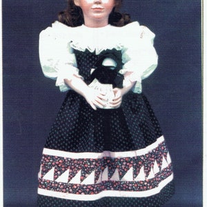 May include: A porcelain doll wearing a white blouse with a lace collar and a black and white patterned skirt. The doll is holding a black and white bird in its hands.