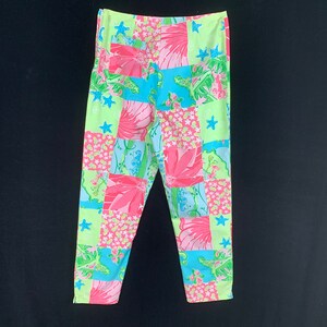 Pu&ograve; includere: Un paio di pantaloni rosa, verdi e blu con un design a patchwork. I pantaloni hanno una vestibilit&agrave; rilassata e una gamba dritta.