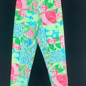 Pu&ograve; includere: Un paio di pantaloni a gamba dritta e vita media con un design a patchwork verde, rosa e blu.