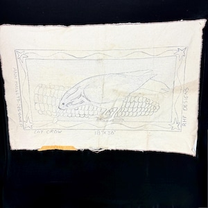 May include: A rectangular off-white fabric panel featuring a black line drawing of a crow perched on a corn cob. The design includes stars in the corners, the text "ANN HALLETT-DESIGNER", "RHF DESIGNS", "EAT CROW", and "18" X 36"" printed on the fabric.