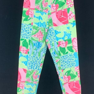 Pu&ograve; includere: Un paio di pantaloni a gamba dritta e vita media con un design a patchwork verde, rosa e blu.