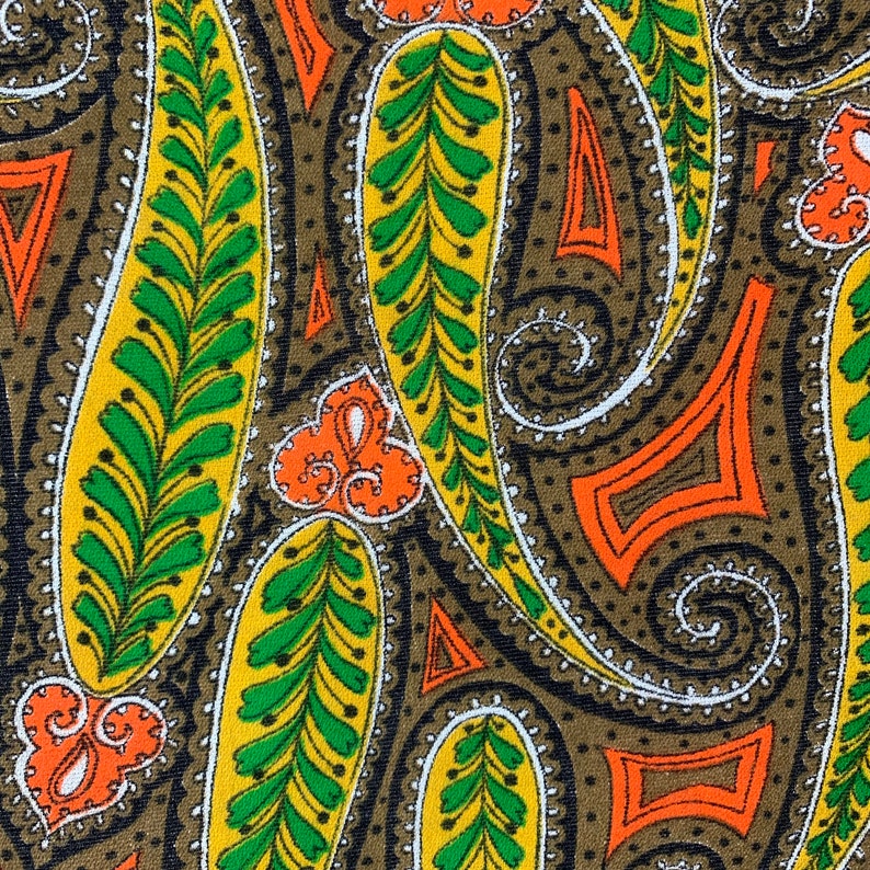 Peut inclure: Un tissu &agrave; motif paisley avec un fond brun et des formes paisley jaunes, vertes et orange.