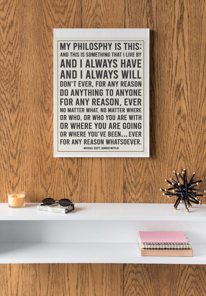 May include: A framed print with the quote "My Philosophy Is This" by Michael Scott from The Office. The print is displayed on a white shelf with sunglasses, a candle, and a decorative object.