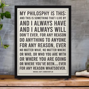 May include: Black framed print with the quote "MY PHILOSOPHY IS THIS" from Michael Scott of Dunder Mifflin. The text is in black on an off-white background. The print is displayed on a wooden surface.