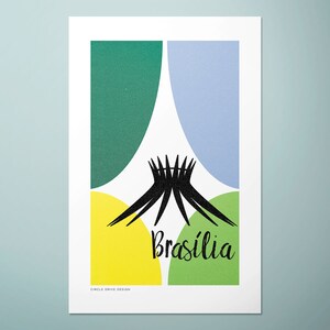 May include: A minimalist graphic design print featuring a black silhouette of the National Cathedral of Brasilia, surrounded by green, yellow and blue circles. The text "Brasília" is written in black cursive below the cathedral.