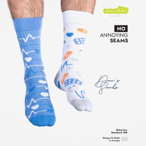 Op de afbeelding: Twee paar sokken. Eén sok is lichtblauw met een wit hartslagpatroon en blauwe harten. De andere sok is wit met een medisch thema, met verbanden, harten en pillen. De sokken zijn gelabeld met "Doc's Socks".