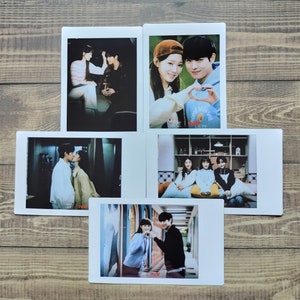 Könnte beinhalten: Fünf Fotos im Polaroid-Stil mit Bildern von Menschen. Die Fotos zeigen Paare und Gruppen von Freunden. Die Bilder sind auf weißem Fotopapier gedruckt, und der Hintergrund ist eine Holzoberfläche.
