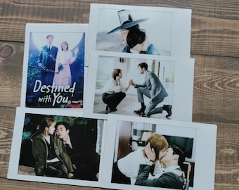 May include: A set of four polaroid photos featuring scenes from the Korean drama "Destined with You". The photos show the main characters in different settings, including a couple standing together, a woman in a traditional Korean dress, and a couple kissing.