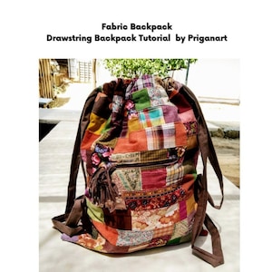 Pode incluir: Uma mochila de cordão de tecido patchwork com alças marrons. A mochila é feita de vários tecidos coloridos, incluindo vermelho, verde, azul e amarelo. A mochila tem um bolso com zíper na frente.