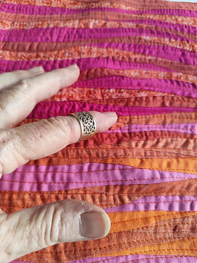 Sunrise wave landscape patchwork art quilt finger on it to show narrow strips