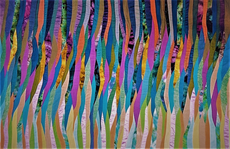 May include: Abstract art quilt with a colorful, wavy pattern. The quilt is made up of many different fabric strips sewn together to create a flowing, organic design. The colors are vibrant and varied, including shades of blue, green, purple, orange, and yellow.