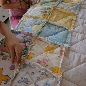 May include: A patchwork quilt being sewn together with different floral patterns in shades of blue, yellow, pink, and white.