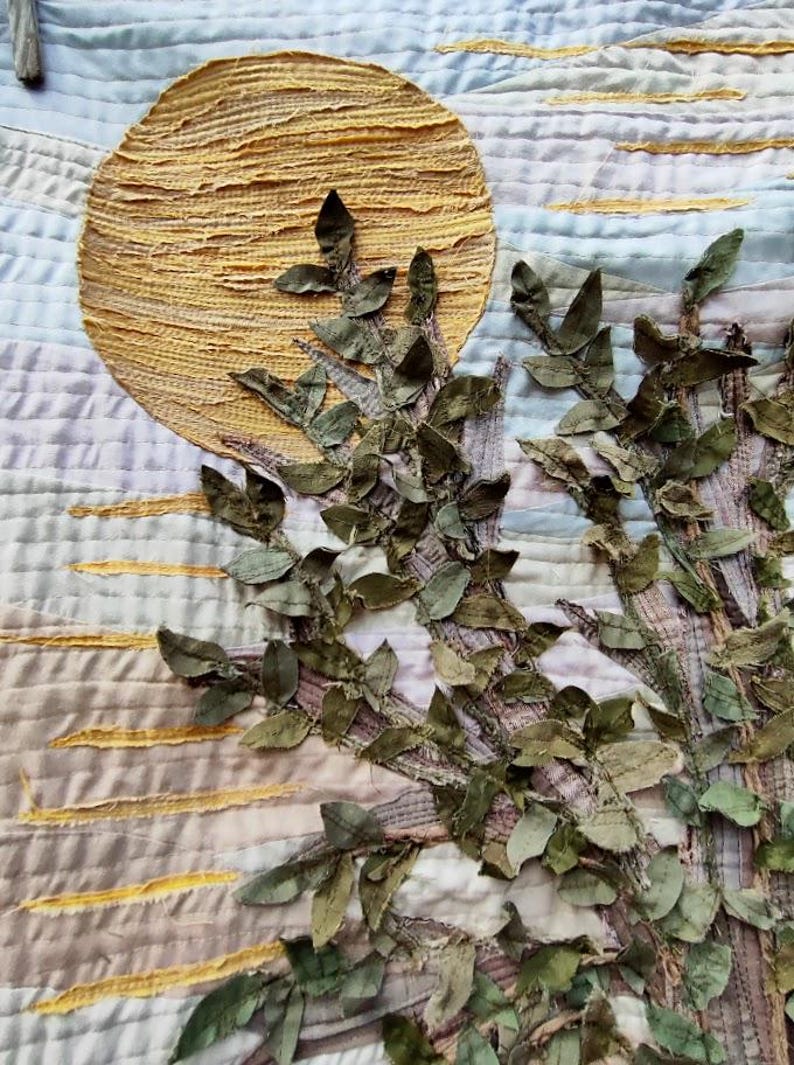 olive leaves on a mustard sun in a patchwork art quilt