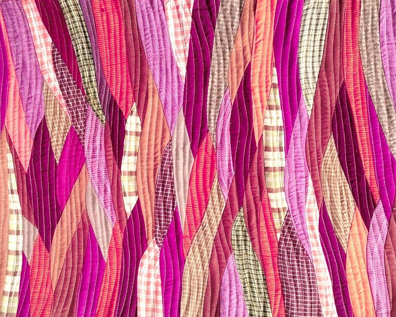 Pu&ograve; includere: Una trapunta realizzata con diverse tonalit&agrave; di rosa, rosso e marrone. Il tessuto &egrave; cucito insieme in un motivo ondulato, creando un design unico e testurizzato.