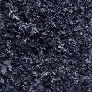 Pode incluir: Close-up de um tecido azul escuro rasgado em pequenos peda&ccedil;os.