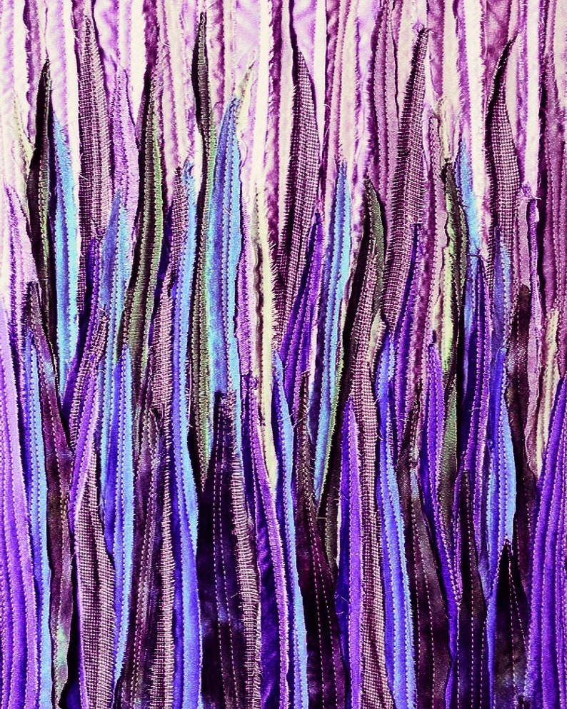 Pu&ograve; includere: Un primo piano di un'opera d'arte in tessuto con strisce verticali di tessuto viola, blu e bianco. Il tessuto &egrave; cucito insieme per creare un design testurizzato e astratto.