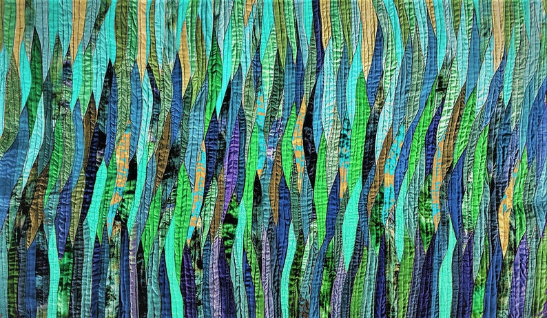 Puede incluir: Colcha de arte abstracto con un patr&oacute;n vertical de tiras largas, delgadas y onduladas de tela en tonos de azul, verde, turquesa y morado.