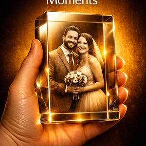 May include: A rectangular glass block featuring a laser-etched 3D image of a couple in wedding attire holding a bouquet. The text "Cherish Your Moments" and "Immortalize your greatest memories in stunning 3D crystal" is printed on the image.