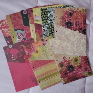 May include: A set of colorful patterned paper dividers with punched holes for a binder. The dividers feature floral and geometric designs in shades of red, pink, green, and yellow.