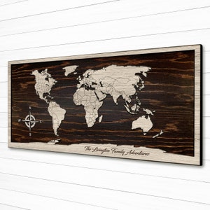 May include: A wooden world map with a compass and the text "The Livingston Family Adventures". The map is dark brown with a light brown frame and a white world map design.