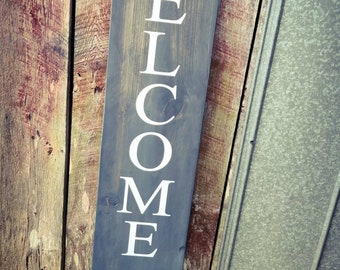 May include: A dark gray wooden sign with white lettering that reads "WELCOME -ISH Depends On Who You Are".