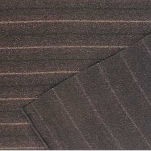 May include: Close-up of a dark brown fabric with thin, light-colored pinstripes running horizontally. The fabric is folded over, revealing the underside. The texture appears soft and possibly wool or a wool blend.