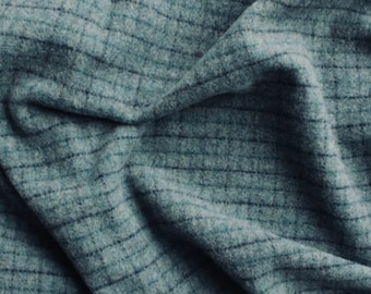 May include: A close-up of a blue and gray plaid fabric with a soft, textured surface.