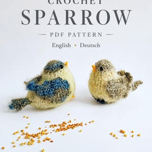 May include: Two small, fuzzy, crocheted sparrow figures with dark eyes and orange beaks, one with blue and cream yarn and one with brown and cream yarn, accompanied by scattered yellow seeds. Text reads: CROCHET SPARROW PDF PATTERN English • Deutsch.