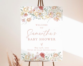 May include: A printable baby shower sign with a floral design in shades of pink, yellow, and green. The sign says "Welcome to Samantha's Baby Shower" and includes the date "May 24th, 20xx". The sign is displayed on an easel.