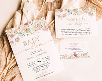 May include: A floral baby shower invitation with a pink and white colour scheme. The invitation features the text "Baby in Bloom" and includes the date, time, and location of the event. The invitation also includes a request for guests to bring a book in place of a card.