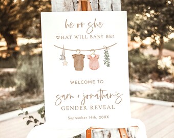 May include: A gender reveal sign with a rustic theme. It says "he or she, what will baby be?" with a clothesline and baby clothes hanging on it. It also says "Welcome to Sam + Jonathan's Gender Reveal, September 14th, 20XX".