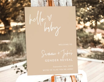 May include: A beige gender reveal sign with the text "hello baby" in white script. The sign also includes the text "Welcome to Sammie + Jake's Gender Reveal" and the date "September 14th, 20XX". The sign is on a wooden easel.