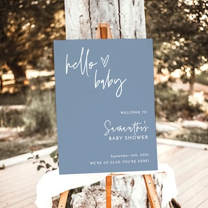 Może przedstawiać: Niebieski znak powitalny z białym tekstem, kt&oacute;ry brzmi "hello baby" i "Witamy na Baby Shower Samanthy" z datą "14 września 2025" i tekstem "Cieszymy się, że jesteś!"