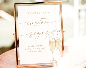 May include: A printable sign with gold text that says "FULLY EDITABLE custom signs CREATE + PRINT AS MANY SIGNS AS YOU'D LIKE" with a gold glitter effect and two champagne glasses with gold liquid and bubbles. The sign is in a gold frame and is sitting on a wooden surface. A Wild Bloom printables.