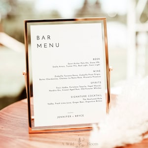 May include: A printable bar menu with a gold frame. The menu lists beer, wine, spirits, and a signature cocktail. The text at the bottom reads "A Wild Bloom printables".