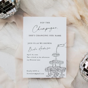 May include: A white invitation card with the text "Pop the Champagne, She's Changing Her Name". The card includes event details and a champagne tower illustration. Two disco balls and decorative elements are in the background.