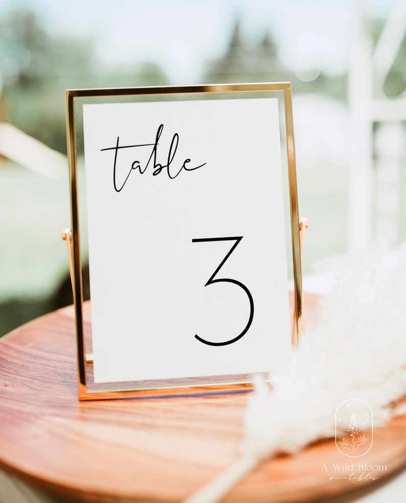 May include: A gold-framed table number sign with the word "table" and the number "3" in black calligraphy.