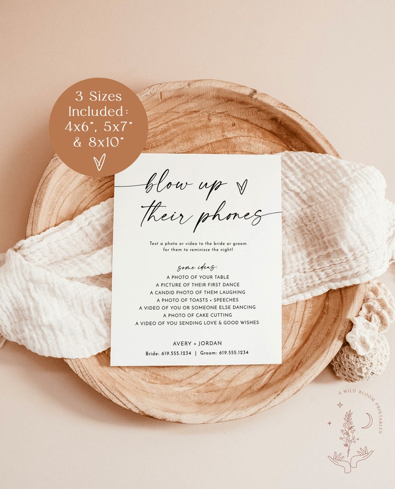 May include: A printable sign with the text "blow up their phones" in black cursive font. The sign is on a light brown wooden surface. The text below the title says "Text a photo or video to the bride or groom for them to reminisce the night!"  Some ideas are listed below: A photo of your table, a picture of their first dance, a candid photo of them laughing, a photo of toasts, speeches, a video of you or someone else dancing, a photo of cake cutting, a video of you sending love & good wishes. The names Avery and Jordan are listed below with phone numbers.