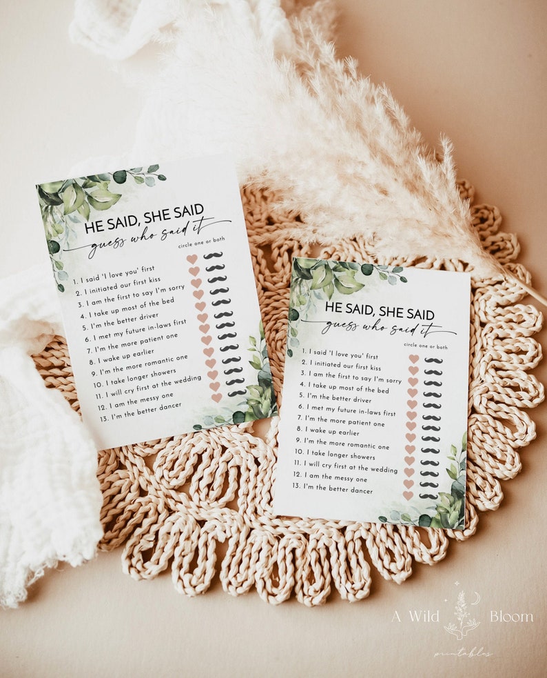 May include: Two "He Said, She Said" game cards with a floral design. The cards have a list of statements with space to circle the answer. The cards are on a woven placemat with a neutral background. The text on the cards reads "He Said, She Said guess who said it."