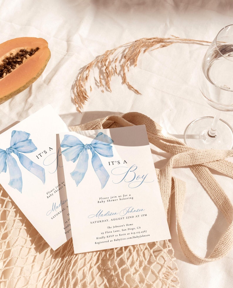 May include: Blue watercolor bow with the text "It's a Boy" on a white card. The card also includes the text "Please join us for a Baby Shower honoring Madison Johnson" and details for the event.