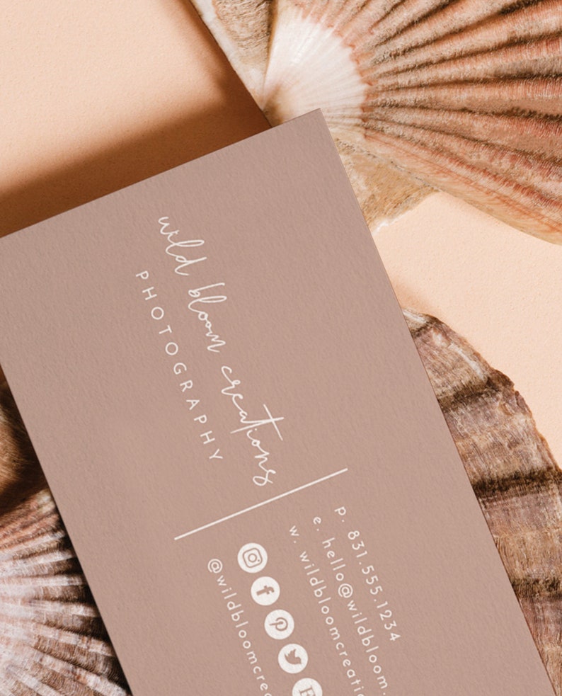 May include: A light brown business card with the text "wild bloom creations PHOTOGRAPHY" in white script font. The card also includes contact information, including a phone number, email address, website address, and social media icons.