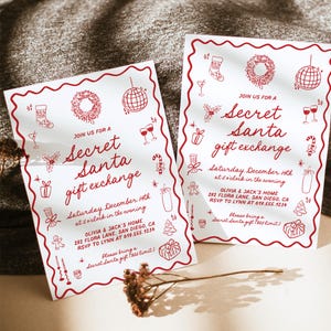 May include: Two white Secret Santa gift exchange invitations with red decorative borders and text. The invitations include holiday-themed illustrations and event details, such as the date, time, and location.