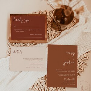 May include: A wedding invitation suite with a rustic theme. The invitation features a brown background with white text that reads "avery + jordan". The RSVP card features a brown background with white text that reads "kindly rsvp".
